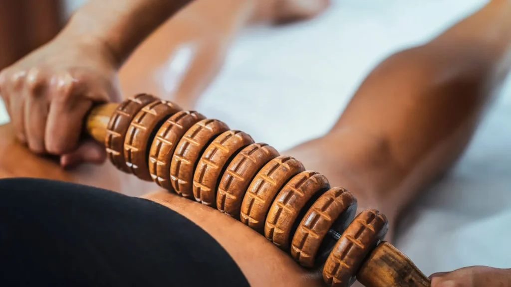 Masaje con rodillo de madera sobre muslo